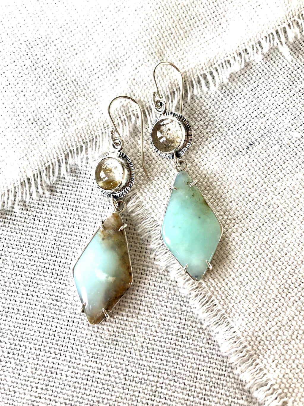 These one of a kind Peruvian blue opal earrings will bring joy and light to any outfit.  These Peruvian Blue Opal earrings are prong set in sterling silver and paired with rutilated quartz stones to continue the soft muted style. 