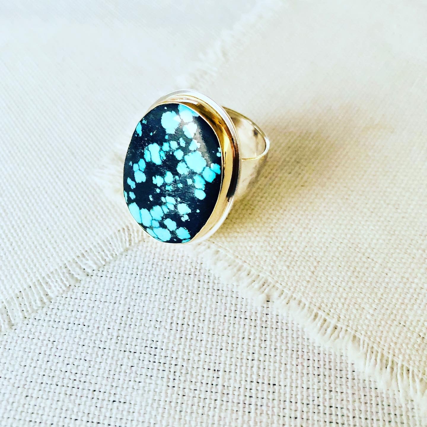 Let this turquoise statement ring compliment your resort lifestyle. The turquoise comes from Hubei and is bezel set in 14kt gold with sterling silver backplate and hand hammered shank.