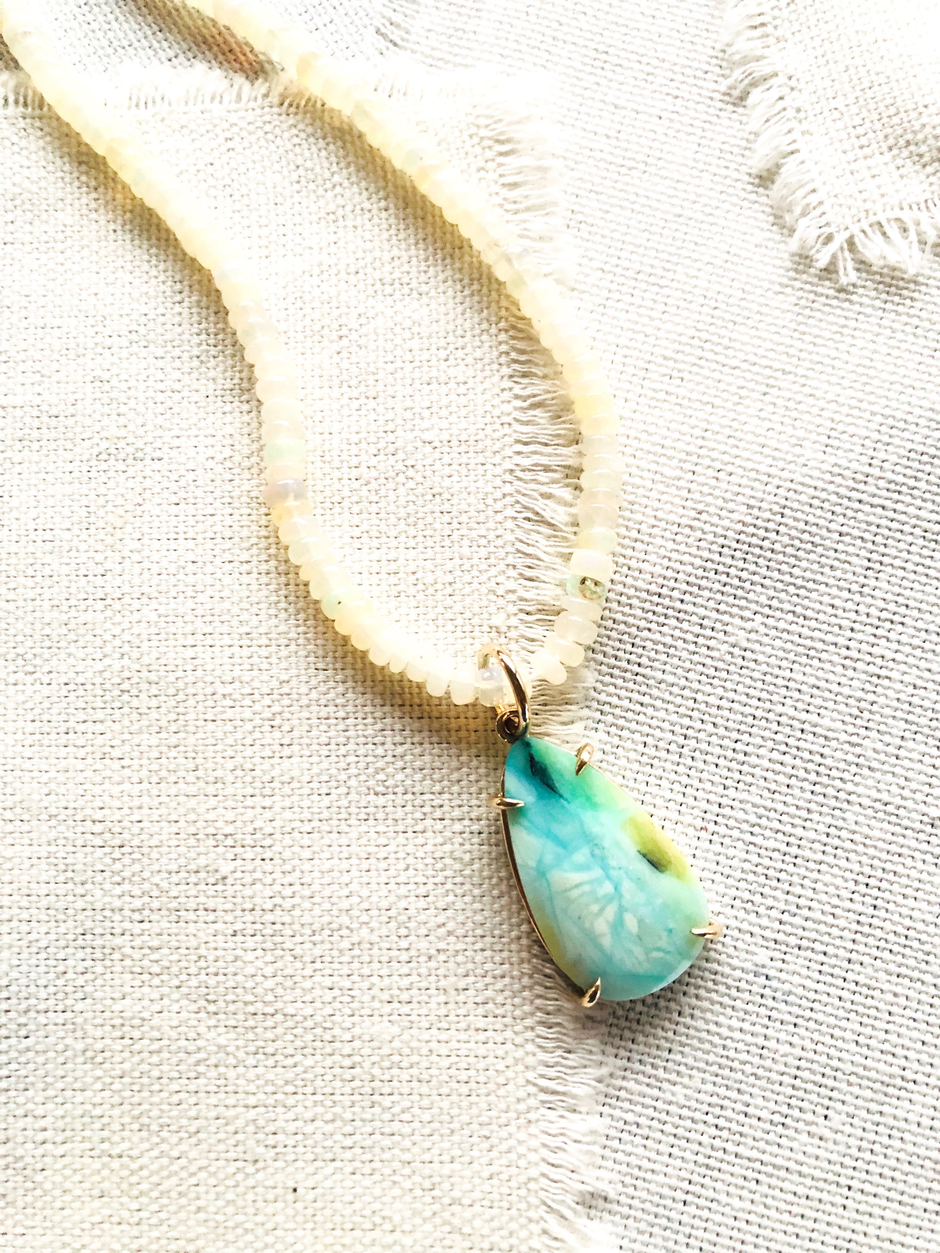 This is a beautiful blue opalized fossilized Indonesian wood pendant strung on Ethiopian Opal beads that reminds me of a confluence of rivers in snow and ice.  