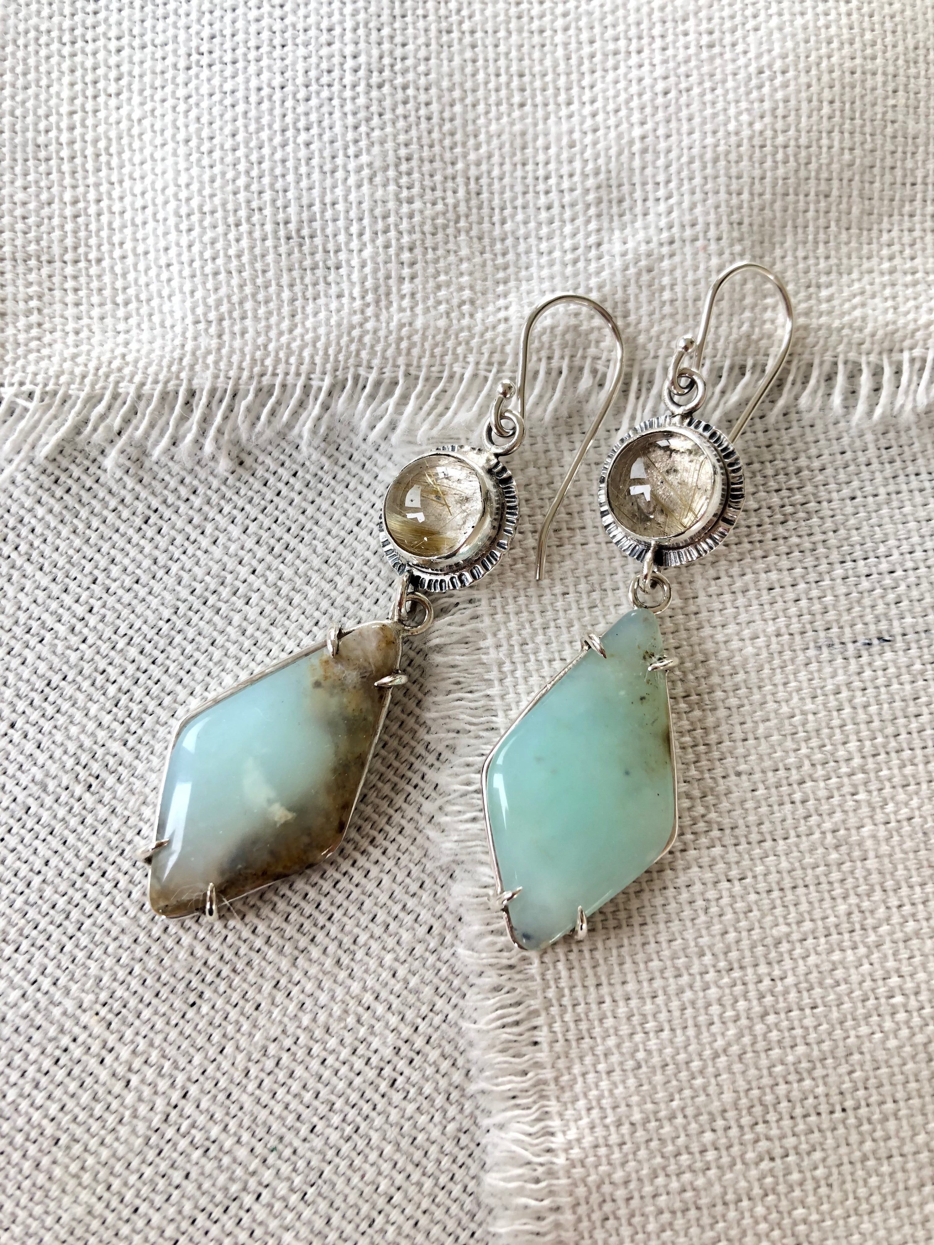 These one of a kind Peruvian blue opal earrings will bring joy and light to any outfit.  These Peruvian Blue Opal earrings are prong set in sterling silver and paired with rutilated quartz stones to continue the soft muted style. 